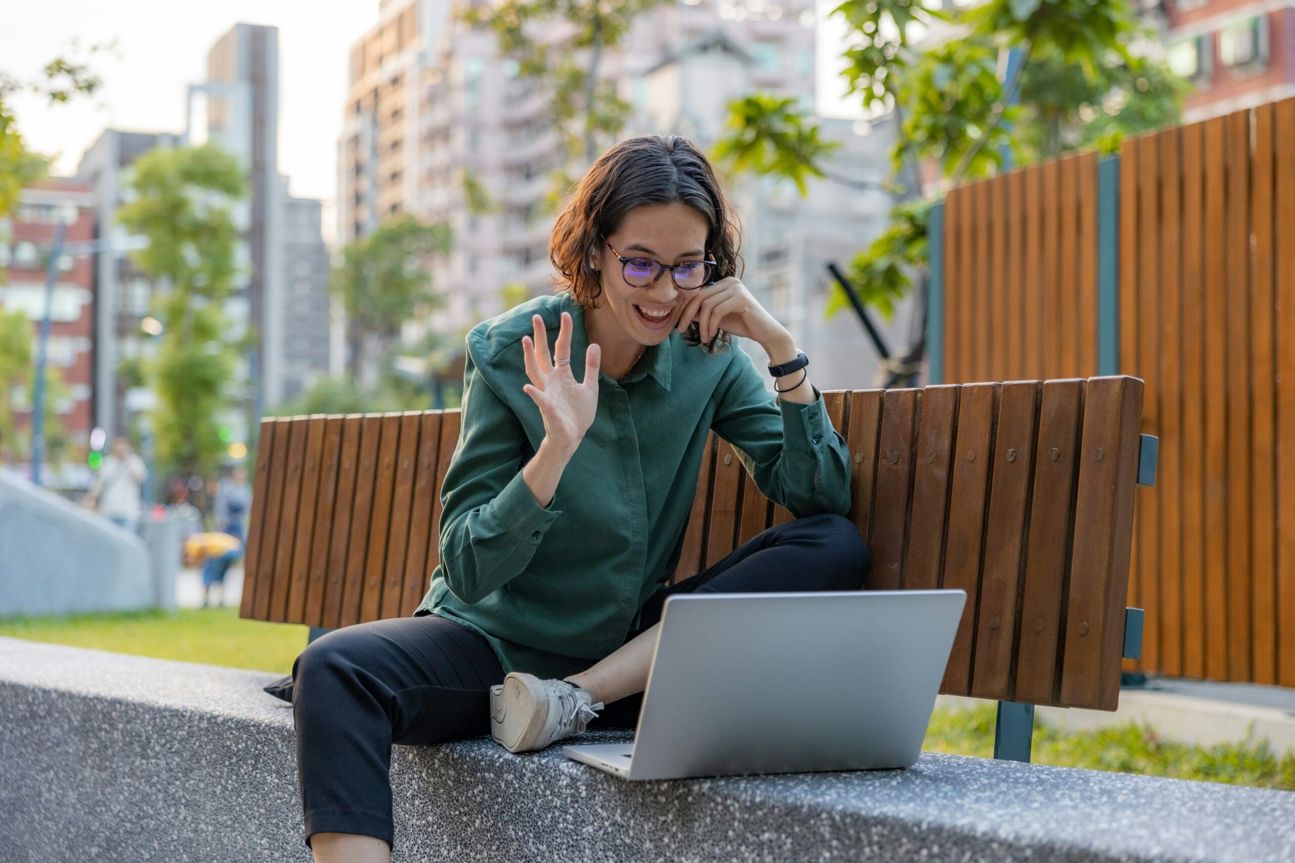 Woman on video call on laptop outdoors